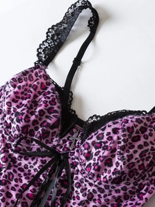 Detail of pink leopard velvet camisole with black lace trim and a silver cross pendant