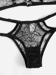 Close-up of black lace thong with silver bat metal ornament for Halloween