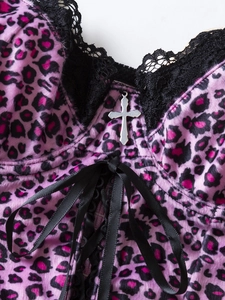 Detailed close-up of pink leopard velvet corset with black lace trim and silver cross