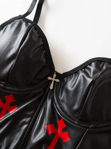 Close-up of black PU leather corset top featuring red crosses and silver cross pendant