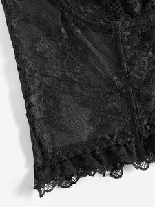 Detailed macro view of black floral lace fabric with delicate mesh and ruffled edge trim