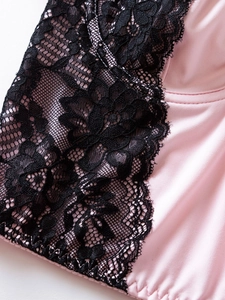 Détail du tissu en soie rose avec broderie complexe en dentelle florale noire