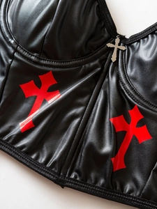 Detail of PU leather corset top featuring red cross prints and silver metal pendant