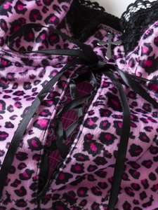 Detail of pink leopard velvet camisole with black lace trim and cross pendant