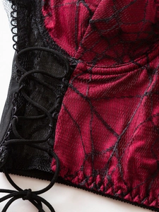 Detail of red gothic camisole featuring black spiderweb lace and side lace-up design