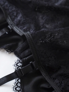 Detailed macro view of black floral lace fabric and adjustable straps on camisole