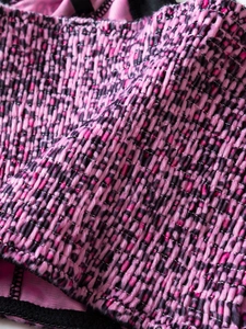 Close-up of pink leopard velvet fabric with elastic smocking and black lace trim detail