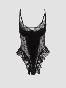 Detail of black velvet bodysuit featuring intricate lace patterns and a deep V-neckline
