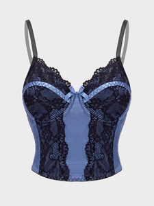 Detailed shot of dark blue satin camisole with black lace trim and bow knot detail
