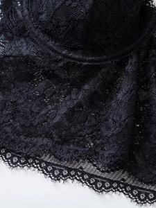 Detailed macro view of black floral eyelash lace fabric and delicate crochet texture