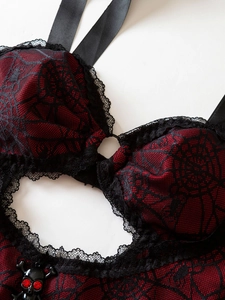 Close-up of red and black gothic lace bodysuit featuring a heart cutout and skull charm