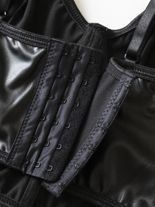 Detail of black PU corset top featuring multi-row hook-and-eye closure and adjustable straps