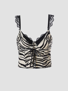 Detail of zebra print corset top featuring black lace trim and ribbon lacing with cross charm
