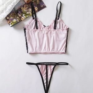 Ensemble de lingerie rose et noir en satin et dentelle avec bretelles sur fond blanc pur