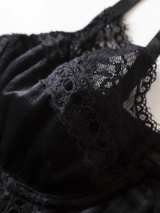 Close-up of elegant black velvet and intricate eyelash lace detail on bodysuit