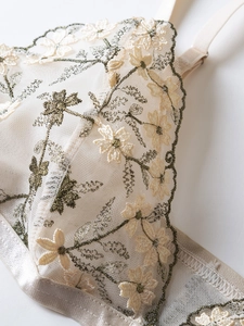 Detail of floral embroidery on off-white mesh bra with premium champagne satin trim