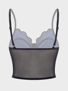 Detailed close-up of adjustable straps and lace trim on a blue mesh camisole top