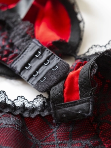 Close-up of the adjustable back closure and black lace detail on the red bodysuit