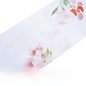Detailed close-up of white satin fabric with vibrant floral print and silky smooth texture