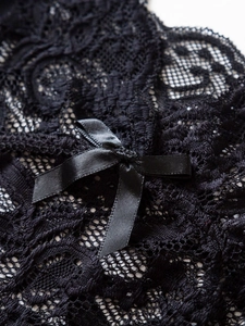 Détail de dentelle noire délicate avec un nœud en satin sur une lingerie sexy