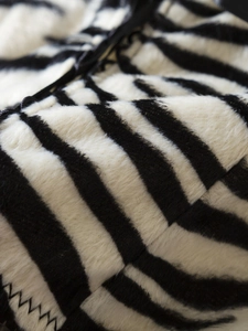 Macro shot of plush Y2K zebra print velvet fabric showing soft texture and fiber detail