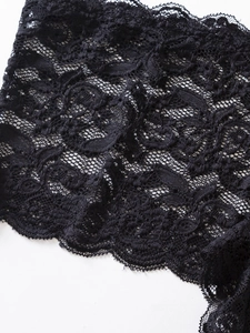 Vue macro détaillée du motif floral en dentelle noire et de la structure en maille