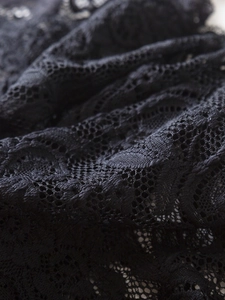 Gros plan sur un tissu de dentelle noire avec broderie florale complexe et texture résille