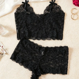 Ensemble lingerie en dentelle noire avec caraco col en V et culotte sur fond en peluche
