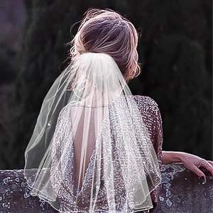Elegant white bridal veil with comb for wedding party shown in a scenic outdoor back view