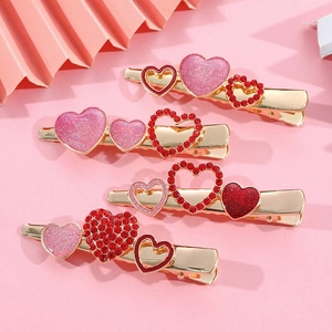 Set di fermagli per capelli a forma di cuore con cristalli rosa su sfondo rosa chiaro
