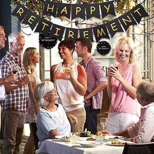 Detail showing Happy Retirement black and gold banner and swirl decorations at a festive party