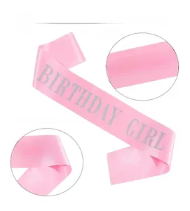 Close-up of pink satin birthday girl sash with silver glitter lettering detail