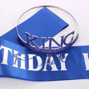 Close-up of blue satin Birthday King sash and silver rhinestone crown with king lettering