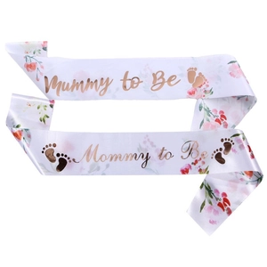 White satin Mummy to Be sash with rose gold foil lettering and pink floral patterns