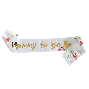 Detail of white satin Mummy to Be sash with gold foil lettering and floral design
