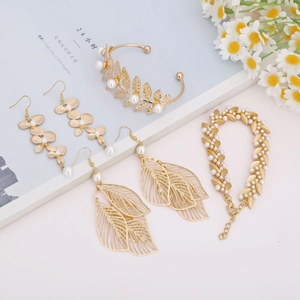 Vue détaillée d'une parure de bijoux dorés avec feuilles et perles pour mariée