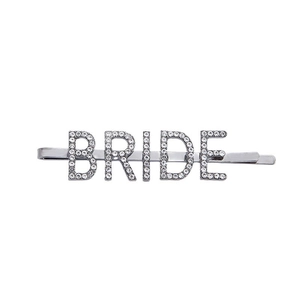Detail view of silver hair pin featuring BRIDE lettering inlaid with sparkling rhinestones