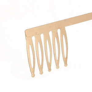 Vue macro d'un peigne à cheveux doré à 6 dents avec des pointes arrondies en alliage poli