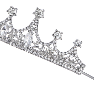 Detailed view of silver crown headpiece with sparkling crystals and rhinestones