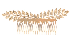 Detailed macro view of vintage golden alloy leaf hair comb with textured olive branch design