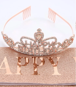 Detailed close-up of rose gold birthday tiara with sparkling rhinestones and heart gem