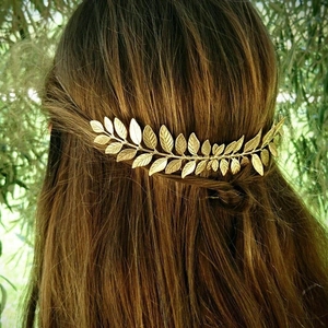 Macro detail of a golden laurel leaf hair comb with textured veins on elegant hairstyle