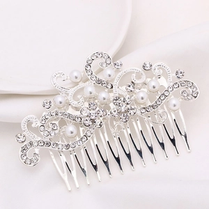 Macro detail of silver alloy bridal hair comb with elegant pearls and rhinestone swirls