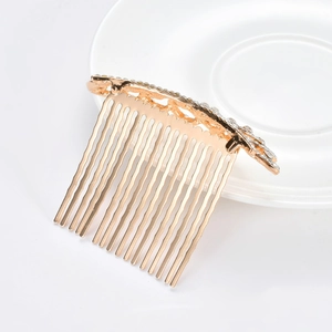 Détail d'un peigne à cheveux doré avec strass blancs sur une assiette en céramique blanche