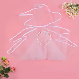 Elegant bridal veil headband with white mesh tulle and decorative pearls on pink background
