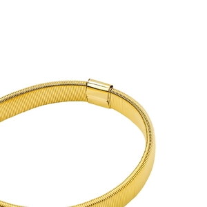 Close-up of golden metal spring armband with polished central clasp on white background