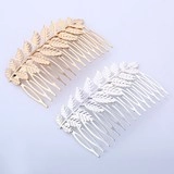 Detail of gold and silver leaf hair combs with intricate metal feather carvings