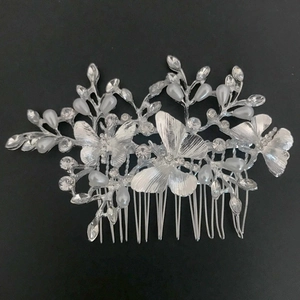 Detailed view of silver butterfly hair comb with sparkling crystals and drop pearls