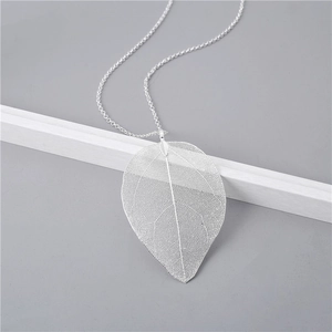 Detailed macro view showing the intricate hollow leaf texture on a silver natural necklace