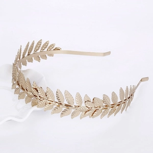 Detailed view of golden leaf bridal headband with realistic texture on a ceramic plate
